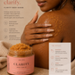 Her•Yang Clarity™ Body Acne Scrub in a white jar, featuring exfoliating beads and a creamy texture for body skincare.