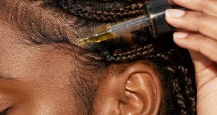 Her•Yang Temple Bloom™ Hairline & Edge Elixir hair oil bottle with dropper, designed for hairline and edges care.